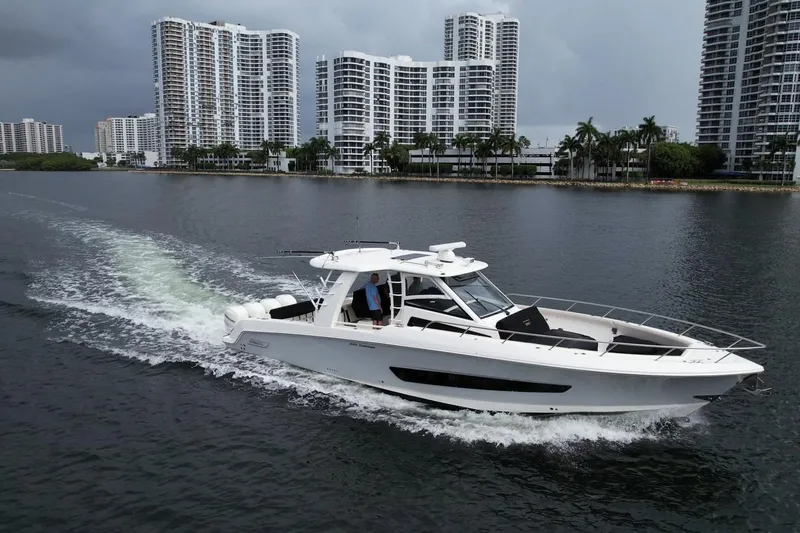 Slide: The Image of 2020 Boston Whaler 420 Outrage cruising near waterfront skyscrapers. - 10