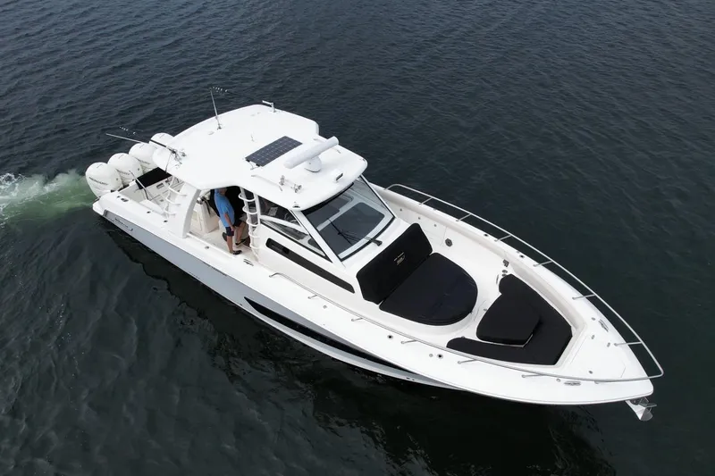 Slide: The Image of 2020 Boston Whaler 420 Outrage cruising on open water, showcasing sleek design and powerful engines. - 11