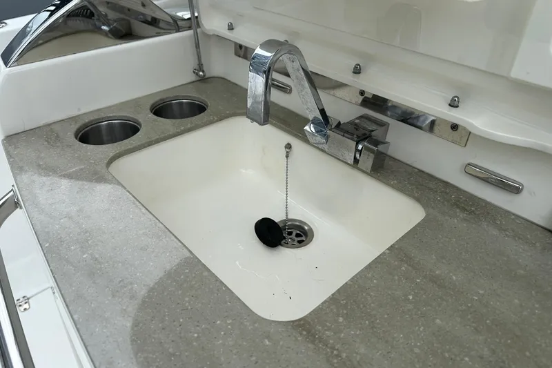 Slide: The Image of Boston Whaler 420 Outrage 2020 boat sink with modern faucet and dual cup holders. - 18