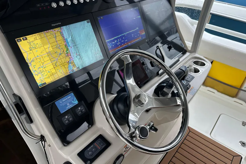 Slide: The Image of 2020 Boston Whaler 420 Outrage helm with navigation screens and steering wheel. - 21