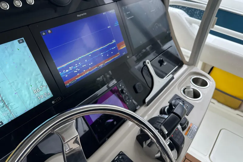 Slide: The Image of Control panel of a 2020 Boston Whaler 420 Outrage with navigation screens and steering wheel. - 23
