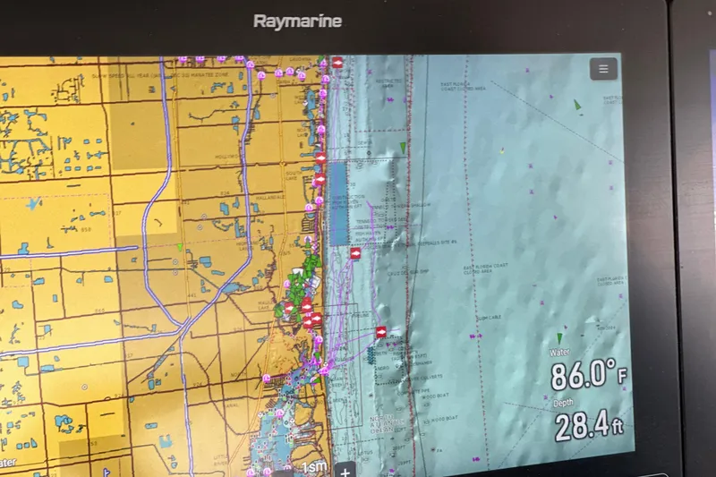 Slide: The Image of Raymarine navigation display on 2020 Boston Whaler 420 Outrage, showing coastal map and water temperature. - 26