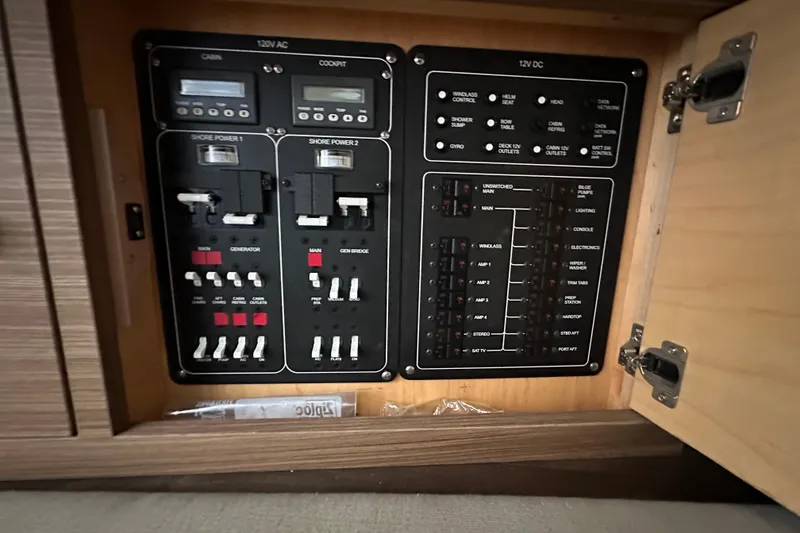 Slide: The Image of Electrical panel inside a 2020 Boston Whaler 420 Outrage boat, showcasing various switches and controls. - 38