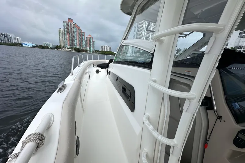 Slide: The Image of 2020 Boston Whaler 420 Outrage cruising near city skyline on a cloudy day. - 39