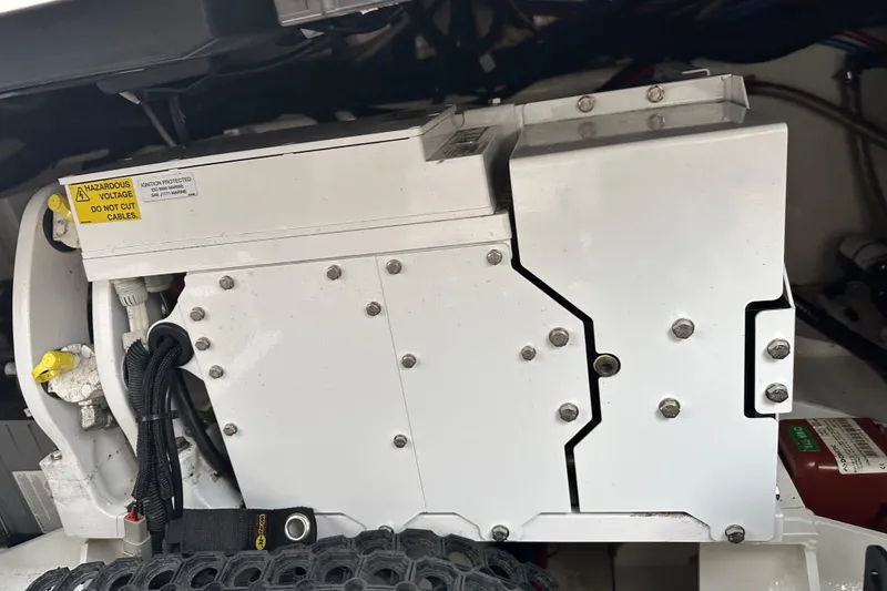 Slide: The Image of Engine compartment of a 2020 Boston Whaler 420 Outrage, featuring electrical components and warning labels. - 42