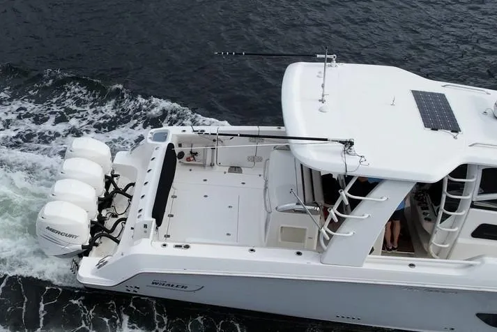Slide: The Image of 2020 Boston Whaler 420 Outrage cruising on water with triple Mercury engines. - 8