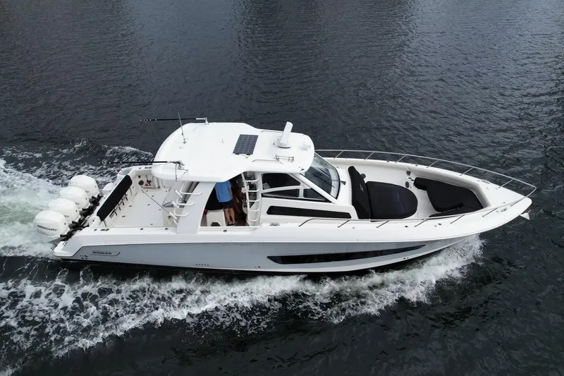 Slide: The Image of 2020 Boston Whaler 420 Outrage cruising on water, showcasing sleek design and powerful engines. - 9