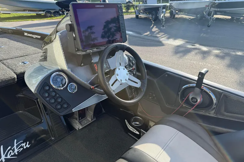 Slide: The Image of 2015 Ranger Z118 Comanche boat cockpit with steering wheel and navigation display. - 16