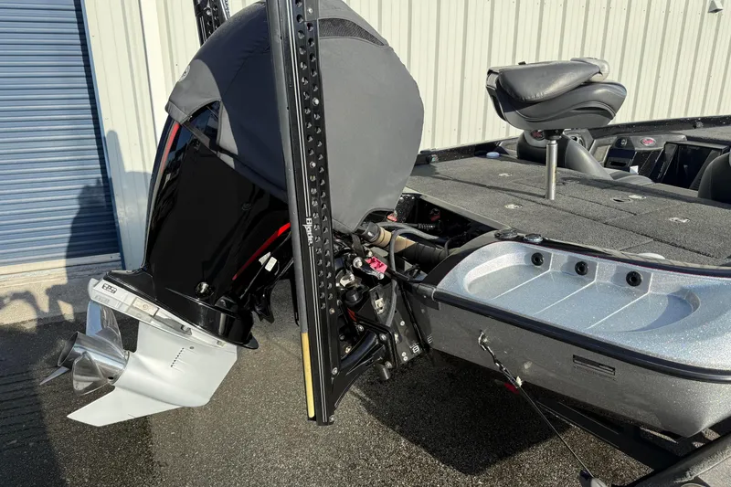 Slide: The Image of 2015 Ranger Z118 Comanche boat with covered outboard motor and seating, parked outdoors. - 5