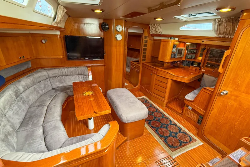 Slide: The Image of Luxurious 1990 Baltic 52 yacht interior with wood finish, plush seating, and navigation station. - 14