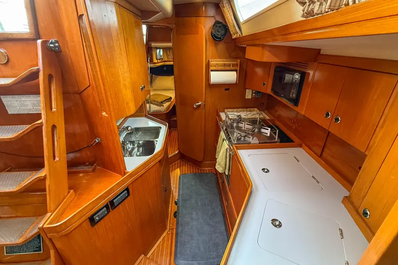 Slide: The Image of Cozy interior of a 1990 Baltic 52 yacht featuring a compact kitchen and wooden cabinetry. - 29