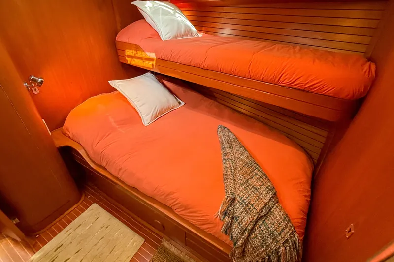 Slide: The Image of Cozy cabin with bunk beds in a 1990 Baltic 52 yacht, featuring warm wood paneling. - 23