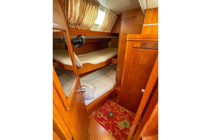 Slide: The Image of Cozy cabin interior of 1990 Baltic 52 sailboat with wooden bunks and floral rug. - 33