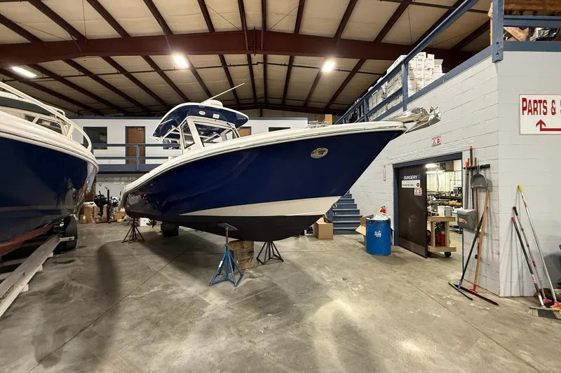 Slide: The Image of 2012 Everglades 275 Center Console boat in a warehouse, elevated on stands. - 13