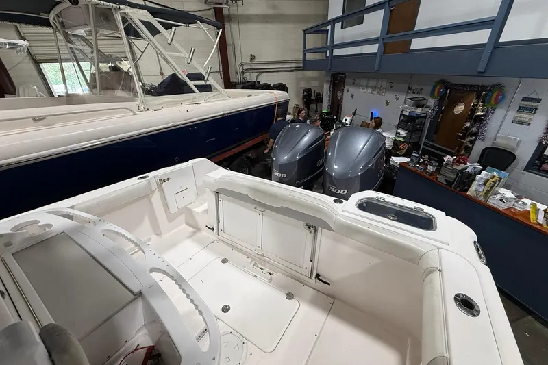 Slide: The Image of 2012 Everglades 275 Center Console boat in a workshop with twin outboard engines. - 7