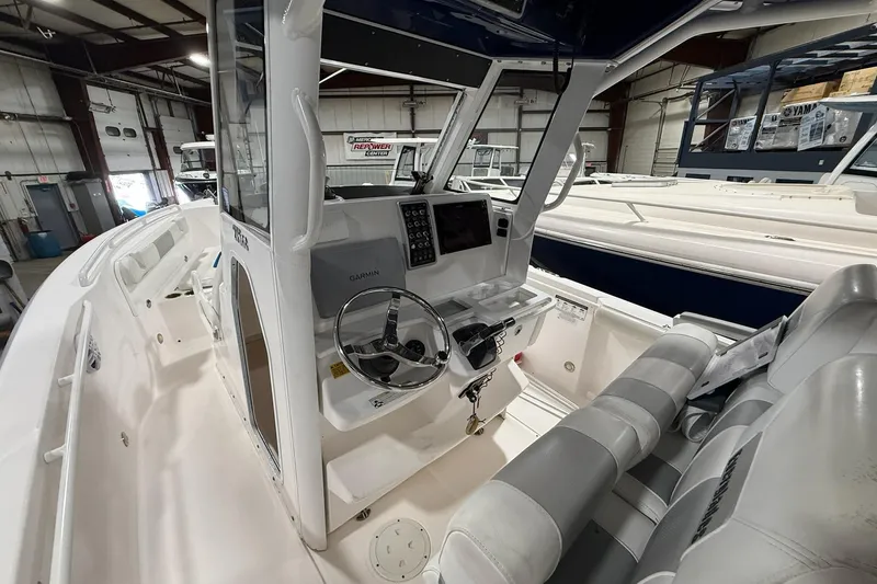 Slide: The Image of 2012 Everglades 275 Center Console boat interior with steering wheel and Garmin display. - 8