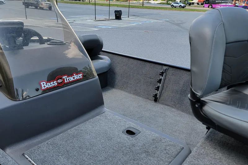 Slide: The Image of 2023 Tracker Bass Tracker Classic XL boat interior with seating and dashboard in a parking lot. - 8