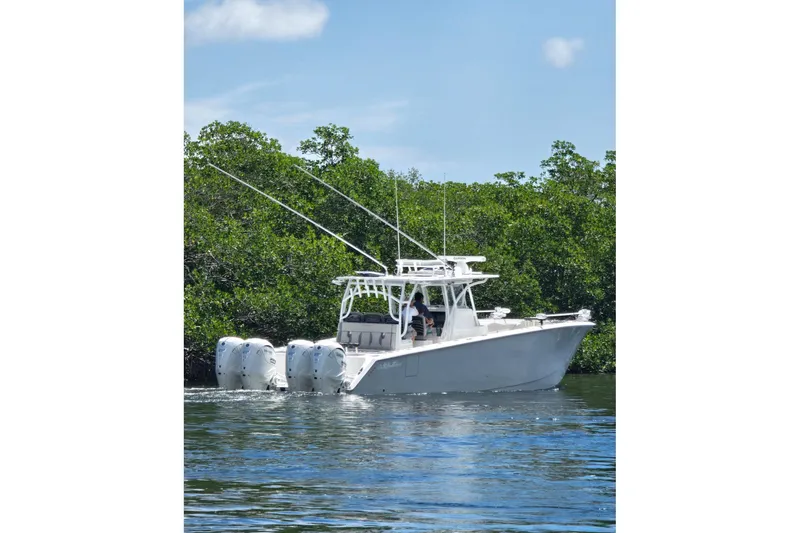 Slide: The Image of 2024 SeaHunter 41 CTS boat cruising on water near lush greenery. - 2
