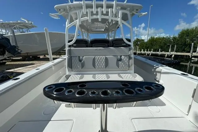 Slide: The Image of 2024 SeaHunter 41 CTS boat interior with seating and rod holders, docked under clear skies. - 6