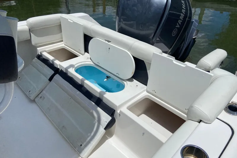 Slide: The Image of 2023 Tidewater 220 LXF boat with open storage compartments and Yamaha engine. - 20