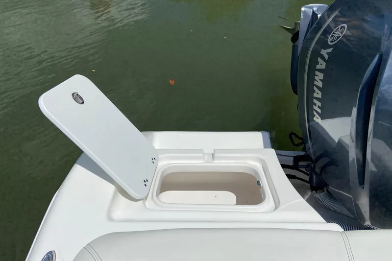 Slide: The Image of 2023 Tidewater 220 LXF boat with open storage compartment and Yamaha engine. - 22