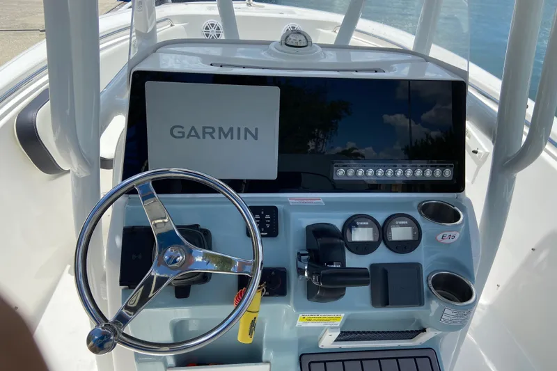Slide: The Image of 2023 Tidewater 220 LXF boat dashboard with Garmin display and steering wheel. - 24
