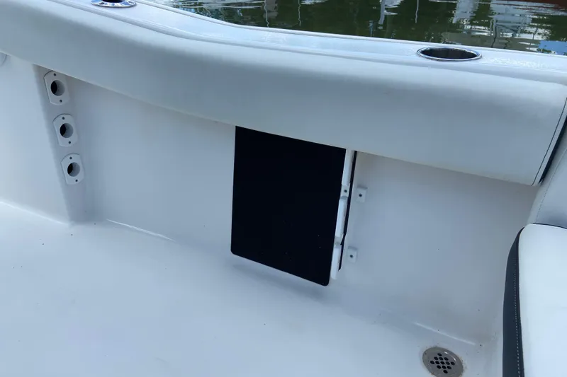 Slide: The Image of 2023 Tidewater 220 LXF boat interior with cup holders and storage compartment. - 28
