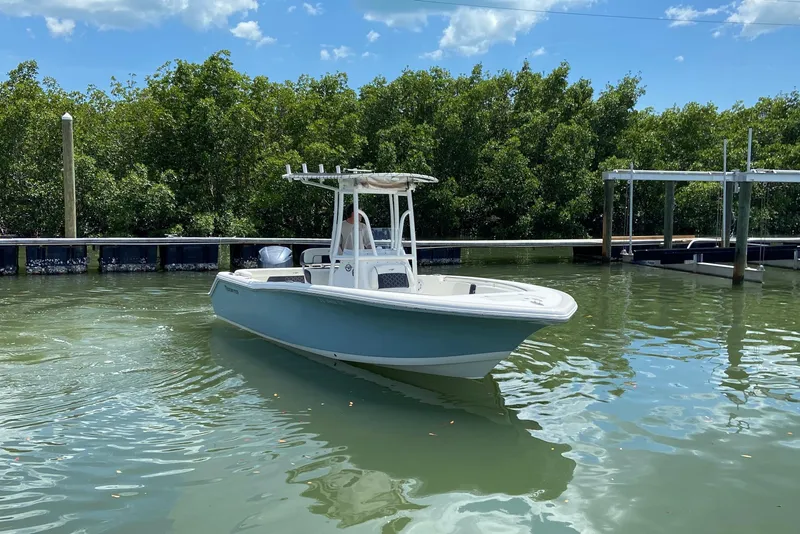 Slide: The Image of 2023 Tidewater 220 LXF boat docked in calm waters, surrounded by lush greenery. - 3