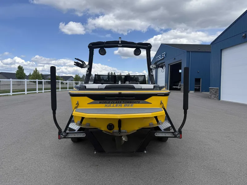 Slide: The Image of Yellow Supreme S202 boat, 2018 model, parked outside blue building. - 6