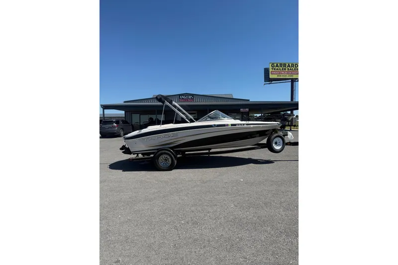 The Image of 2008 Tahoe Q5i Sport boat on trailer in parking lot, clear sky background. - 1