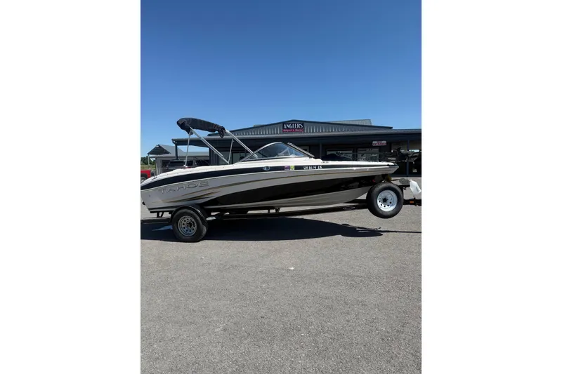 Slide: The Image of 2008 Tahoe Q5i Sport boat on trailer, parked outdoors under clear blue sky. - 2