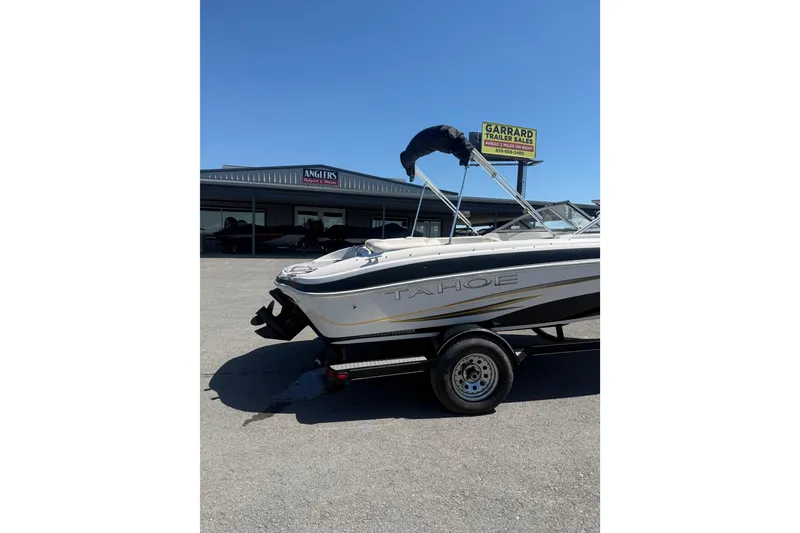 Slide: The Image of 2008 Tahoe Q5i Sport boat on trailer at dealership under clear blue sky. - 7