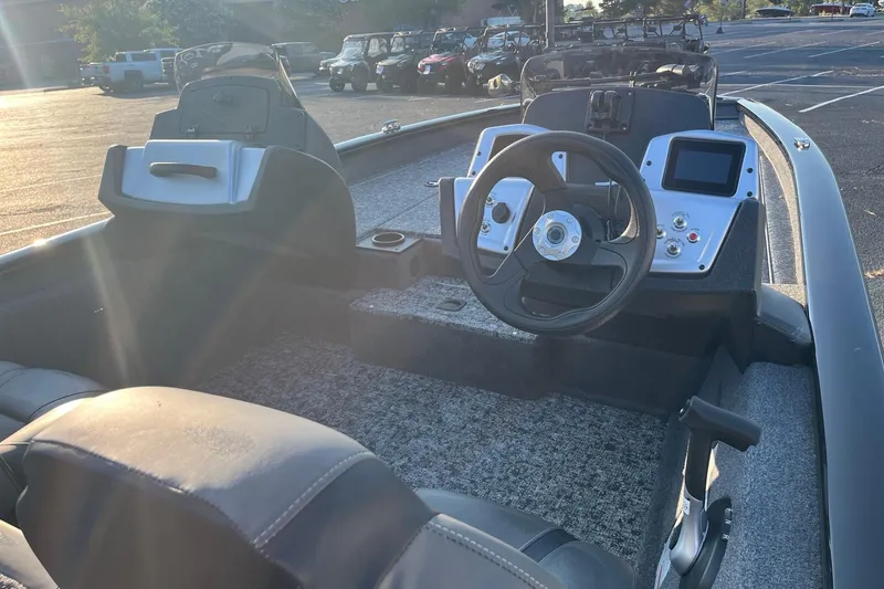 Slide: The Image of 2026 Tracker Pro Team 190 boat interior with steering wheel and dashboard in sunlight. - 7