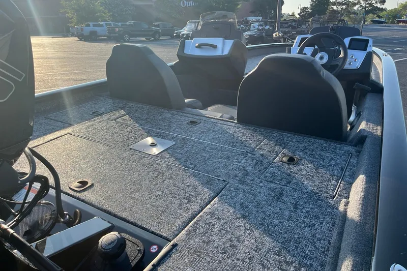 Slide: The Image of 2026 Tracker Pro Team 190 boat interior with seating and control panel in a parking lot. - 6