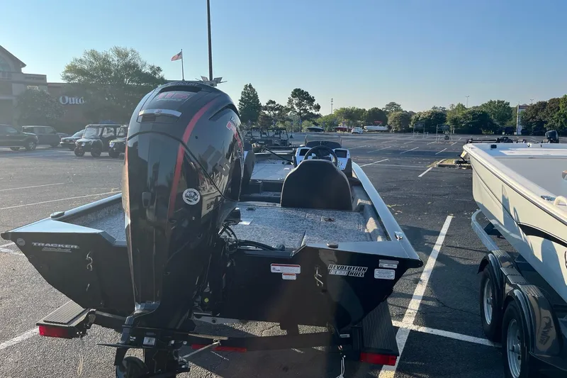 Slide: The Image of 2026 Tracker Pro Team 190 boat with outboard motor in a parking lot. - 4