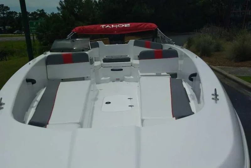 Slide: The Image of 2026 Tahoe T18 boat with red and gray seating, docked outdoors. - 74