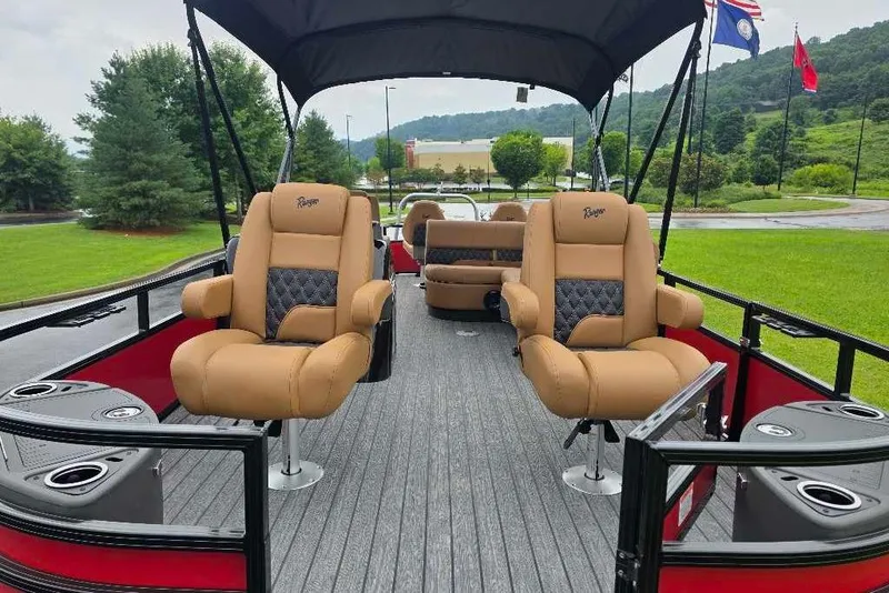 Slide: The Image of 2026 Ranger 220F pontoon boat with tan seating and canopy, parked on grass. - 4