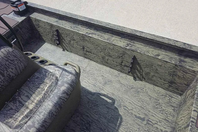 Slide: The Image of Interior view of 2026 Tracker Grizzly 1860 CC boat with camouflage seating and storage. - 10