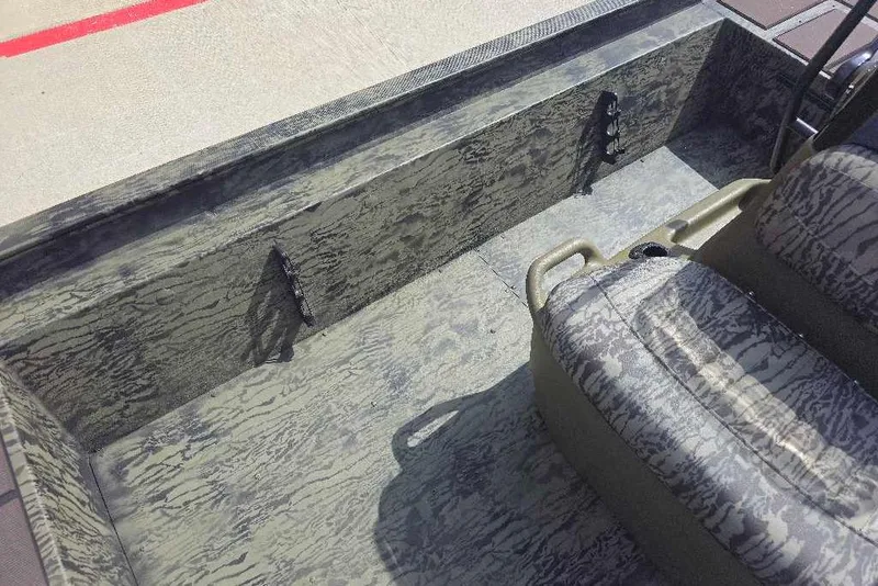 Slide: The Image of Interior of 2026 Tracker Grizzly 1860 CC boat with camouflage seating and flooring. - 12