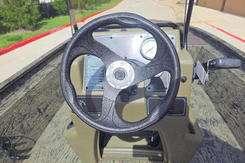Slide: The Image of Steering wheel of 2026 Tracker Grizzly 1860 CC boat, featuring dashboard controls. - 5
