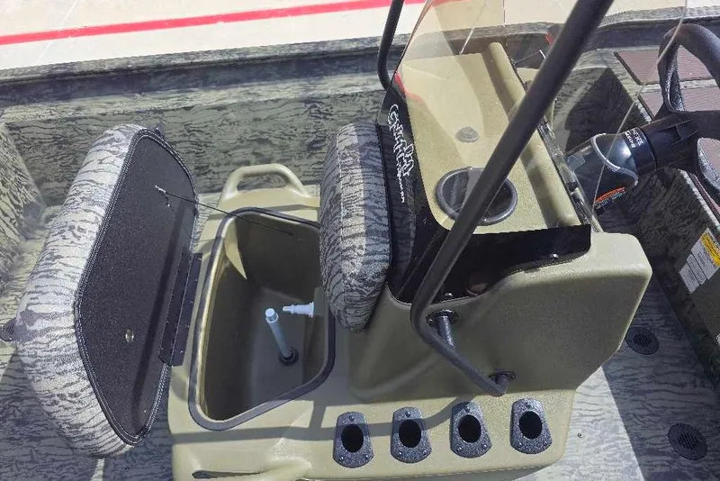 Slide: The Image of 2026 Tracker Grizzly 1860 CC boat interior with open storage compartment and steering console. - 6