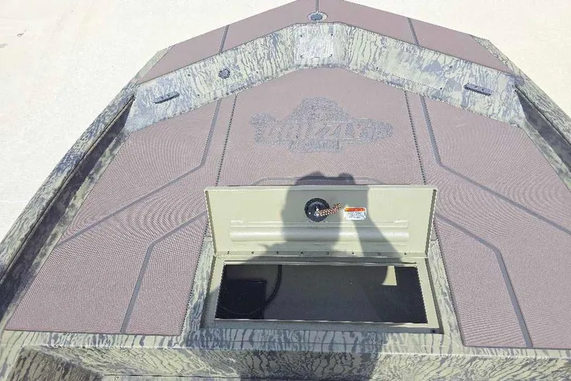 Slide: The Image of 2026 Tracker Grizzly 1860 CC boat deck with open storage compartment. - 7