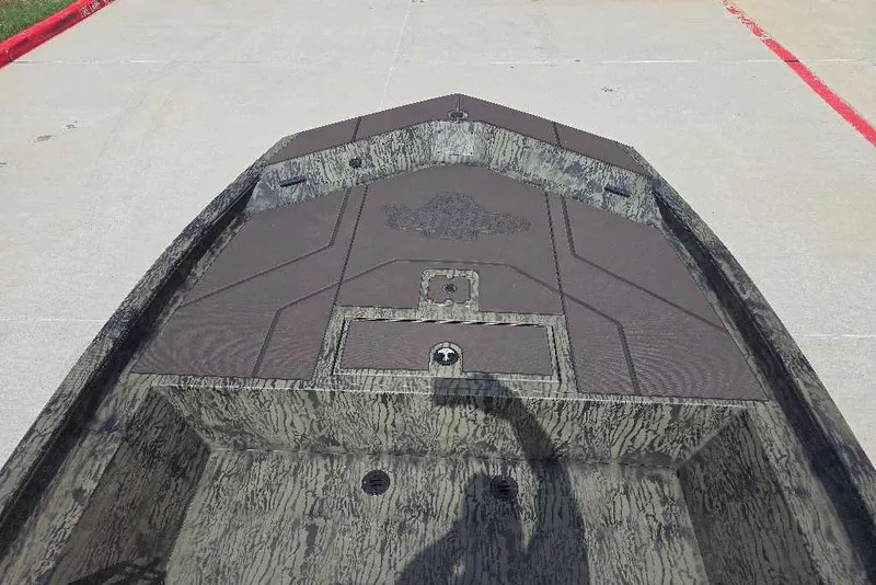 Slide: The Image of 2026 Tracker Grizzly 1860 CC boat deck with camouflage pattern, photographed outdoors. - 8