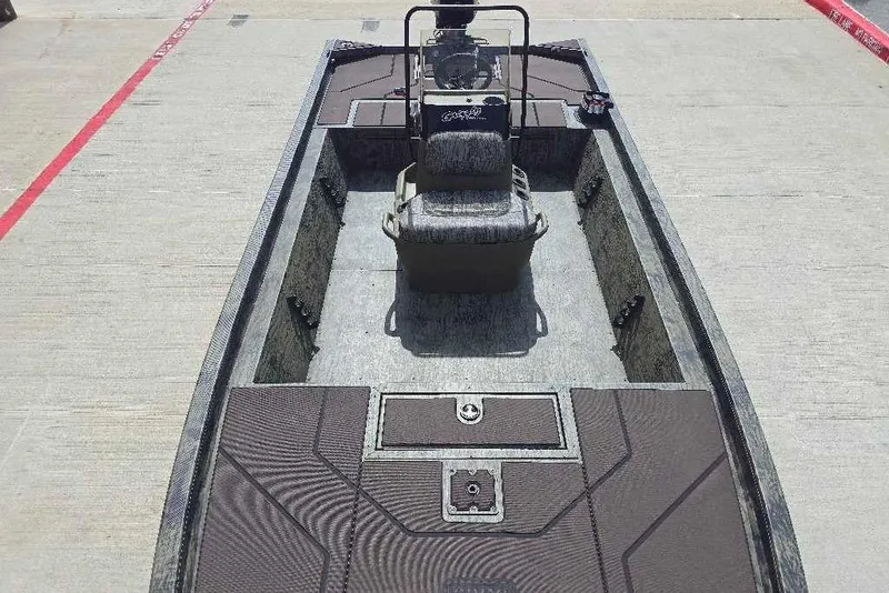 Slide: The Image of 2026 Tracker Grizzly 1860 CC boat with center console and seating, parked on concrete. - 9