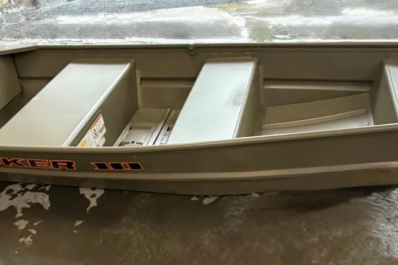 The Image of 2026 Tracker Grizzly 10 Jon boat, gray, on wet surface, showcasing interior seating and design. - 0