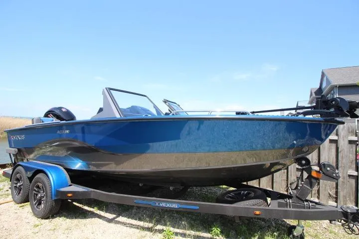 The Image of 2026 Vexus ADX 190 boat on trailer, sleek blue design, parked outdoors. - 0
