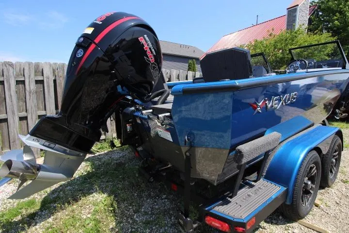 Slide: The Image of 2026 Vexus ADX 190 boat with powerful outboard motor, parked on a trailer. - 2
