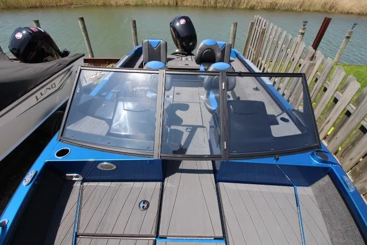 Slide: The Image of 2026 Vexus ADX 190 boat with sleek design, blue accents, and spacious seating on a calm waterway. - 7