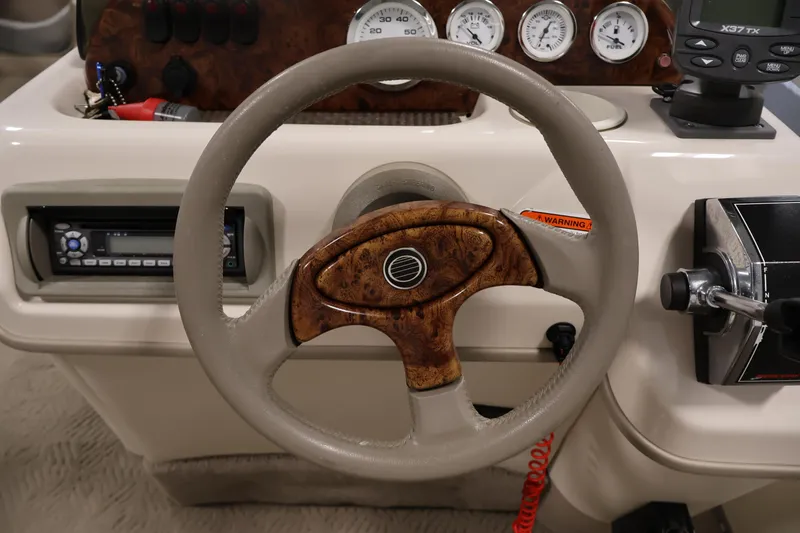 Slide: The Image of 2008 Sun Tracker Party Barge 24 DLX dashboard with steering wheel and control panel. - 24