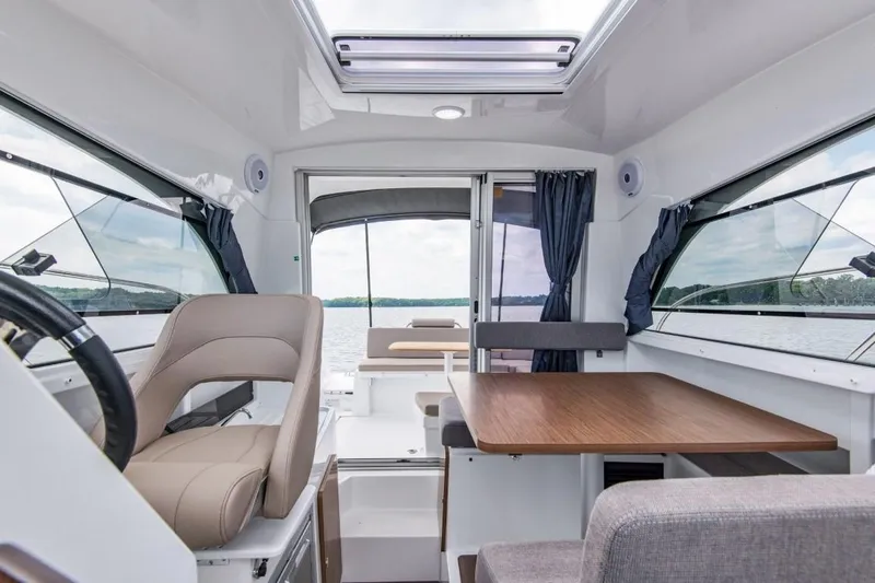 Slide: The Image of Interior of 2024 Beneteau Antares 8, featuring seating and dining area with lake view. - 16